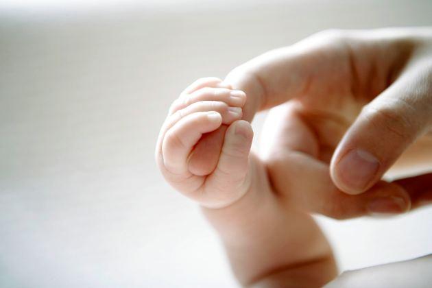 Mano de bebe agarrando un dedo